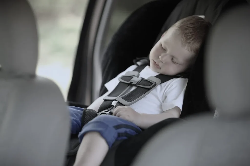 child resting in a secured child seat